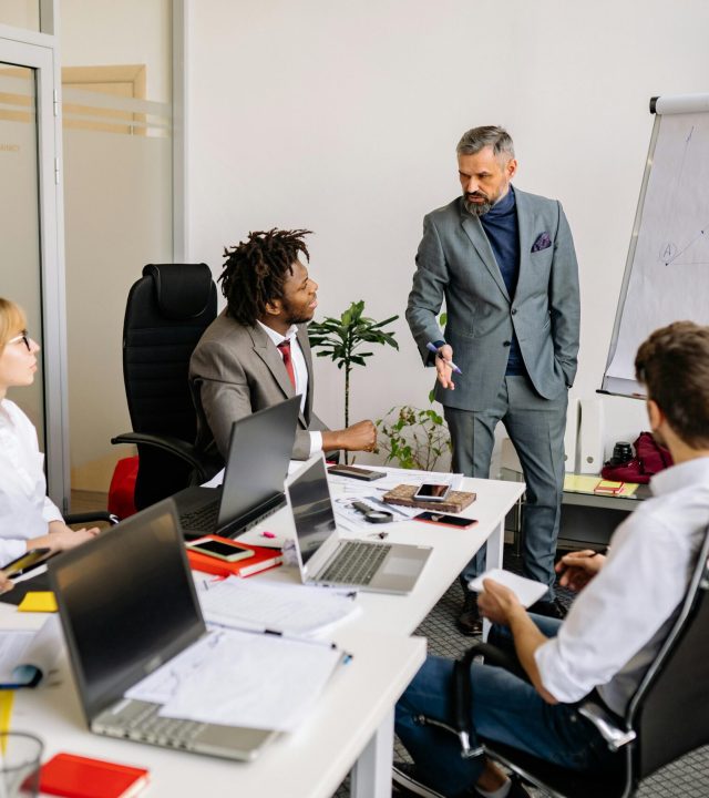 Corporate team in a modern office, engaged in a discussion with diverse colleagues.